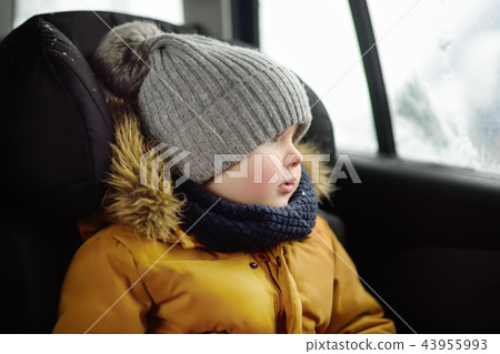 boy sitting in car seat during roadtrip or travel boy sitting in car seat during roadtrip or travel 43955993