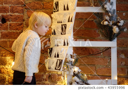 Happy little boy takes sweet from advent calendar 43955996