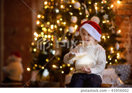 Cute little boy wearing Santa hat on Christmas eve Cute little boy wearing Santa hat on Christmas eve 43956002