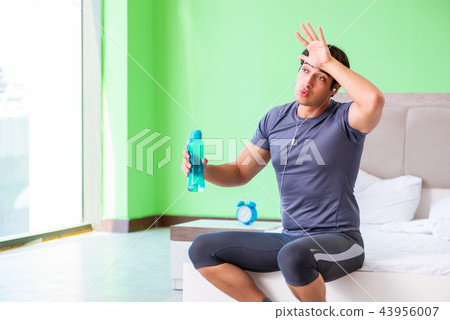 Young handsome man doing morning exercises in the hotel room Young handsome man doing morning exercises in the hotel room 43956007
