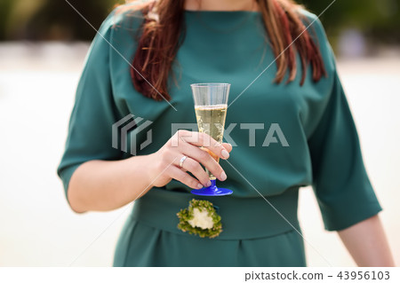 Bride or bridesmaid holding plastic glasses  43956103