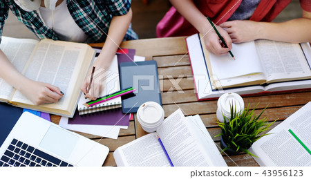 Top view of young students with books and notes Top view of young students with books and notes 43956123
