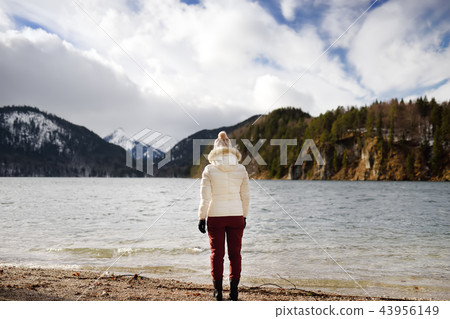Feamle tourist enjoy view of lake Alpsee Feamle tourist enjoy view of lake Alpsee 43956149