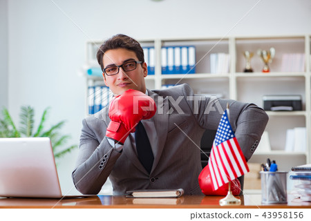 Businessman with American flag in office Businessman with American flag in office 43958156