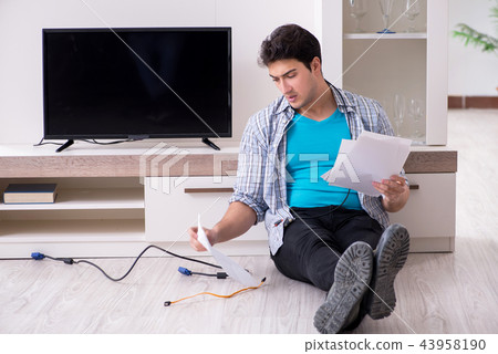 Man trying to fix broken tv Man trying to fix broken tv 43958190