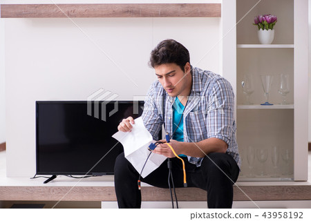 Man trying to fix broken tv Man trying to fix broken tv 43958192