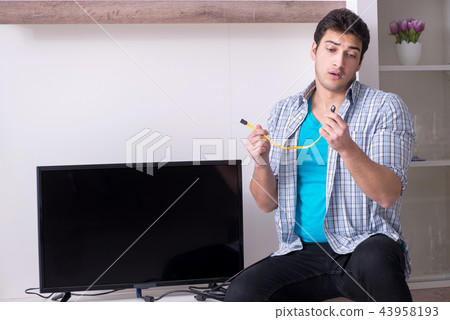 Man trying to fix broken tv Man trying to fix broken tv 43958193