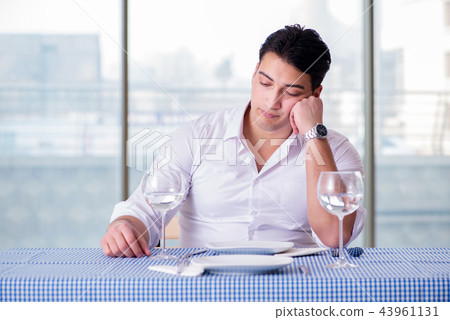 Handsome man alone in restaraunt on date 43961131