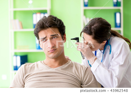 Female doctor checking patient's ear during medical examination  43962548