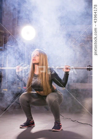 sport, fitness, training and happiness concept - sporty woman with barbell in gym 43964178