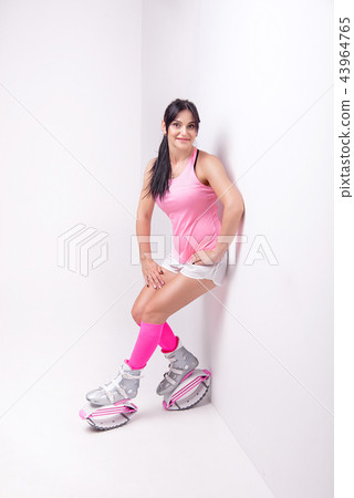 Beautiful athletic woman wearing in sports style clothing with kangoo jumps boots on her legs makes 43964765