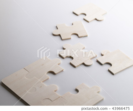 Incomplete puzzles lay on wooden white table Incomplete puzzles lay on wooden white table 43966475