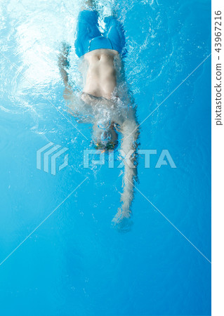 Photo on top of young athlete man swimming on back in swimming pool Photo on top of young athlete man swimming on back in swimming pool 43967216