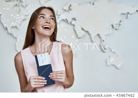 Happy young woman with passports and tickets in the office of travel company Happy young woman with passports and tickets in the office of travel company 43967482