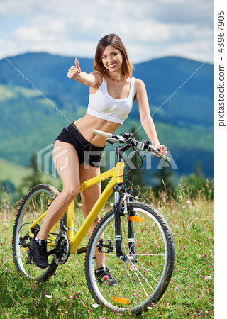 Young happy woman cycling on mountain bike at summer day 43967905
