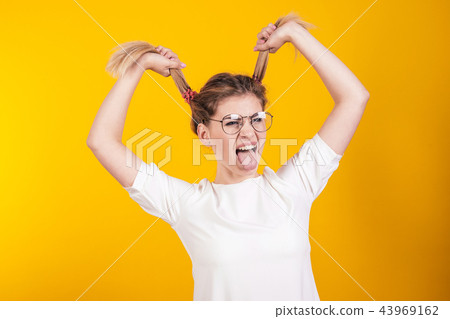 Young girl in glasses shows tongue Young girl in glasses shows tongue 43969162