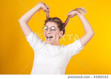 young girl in glasses smiles and keeps tails young girl in glasses smiles and keeps tails 43969163