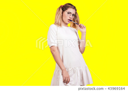 A young woman in glasses and a white dress A young woman in glasses and a white dress 43969164
