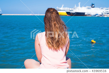 Woman sitting in a Greek port. Woman sitting in a Greek port. 43969516