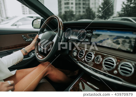 Female arm driving contemporary vehicle with dashboard Female arm driving contemporary vehicle with dashboard 43970979