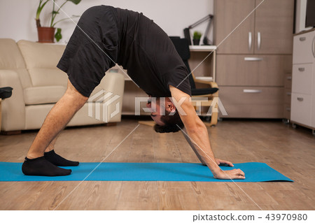 Adult man doing Dolphin yoga pose in his workout routine Adult man doing Dolphin yoga pose in his workout routine 43970980