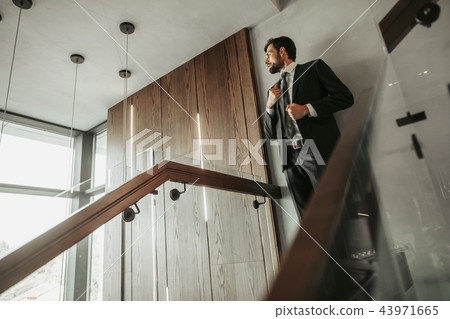 Orderly man locating on modern stairwell landing 43971665