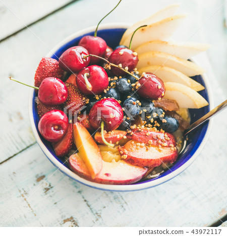Smoothie bowl with fruit and berries, wooden background, square crop 43972117