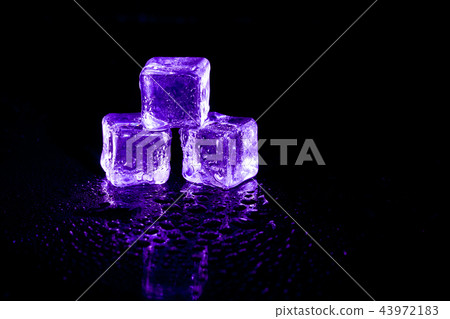 Purple ice cubes reflection on black table. Purple ice cubes reflection on black table. 43972183