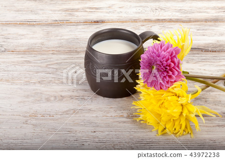 Ceramics handmade mug with milk and flowers Ceramics handmade mug with milk and flowers 43972238