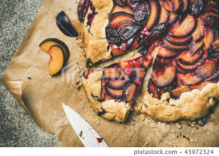 Flat-lay of plum galetta sweet cake on baking paper 43972324