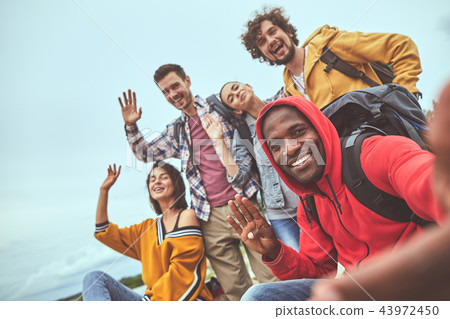 Group of friends waving hands for selfie 43972450
