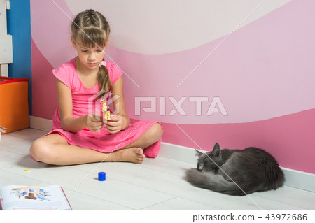 A girl is making figures out of colored paper A girl is making figures out of colored paper 43972686