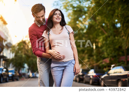 Bearded man hugging his beautiful pregnant wife and touching her belly Bearded man hugging his beautiful pregnant wife and touching her belly 43972842
