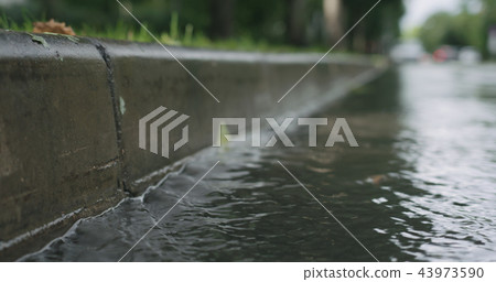 water streams on the street after rain water streams on the street after rain 43973590