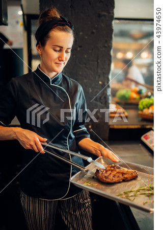 Female cook holds prepared steak, grilled bbq meat 43974650
