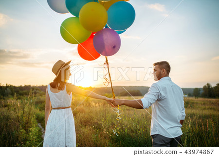 Couple holds balloons and kissing in wheat field 43974867