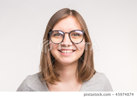 Close-up of young beautiful woman in glasses over white background. Close-up of young beautiful woman in glasses over white background. 43974874
