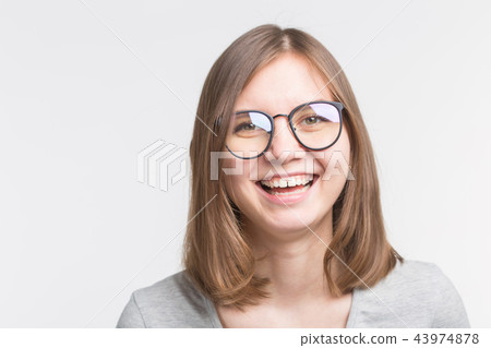 Portrait of laughing happy brown hair girl in a glasses over white background Portrait of laughing happy brown hair girl in a glasses over white background 43974878