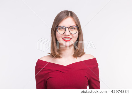 Fashion and people concept - Portrait of young smiling woman in glasses in red shirt on white Fashion and people concept - Portrait of young smiling woman in glasses in red shirt on white 43974884