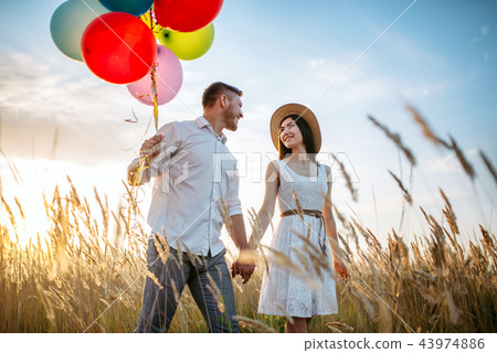 Husband and wife walks with bunch of balloons Husband and wife walks with bunch of balloons 43974886