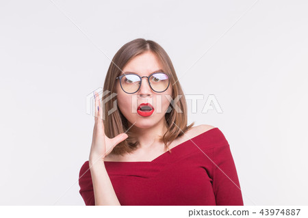 Expressions and people concept - Portrait of young surprised woman in glasses on white background 43974887