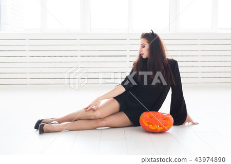 Halloween and holidays concept - Witch woman with Jack O'Lantern pumpkin Halloween and holidays concept - Witch woman with Jack O'Lantern pumpkin 43974890