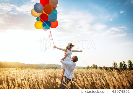 Love couple with balloons hugs in wheat field 43974891