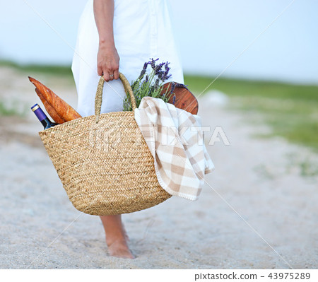 Young woman holding picnic basket  43975289