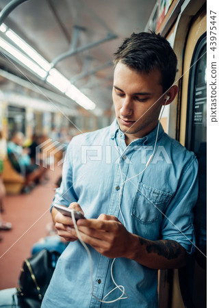 Phone addict man using gadget in metro Phone addict man using gadget in metro 43975447