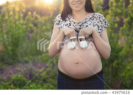 Pregnant woman with baby little shoes Pregnant woman with baby little shoes 43975618
