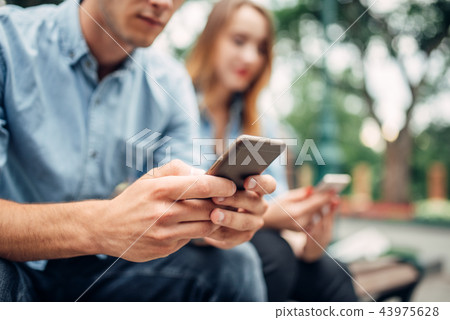 Phone addicted people, couple using smartphones Phone addicted people, couple using smartphones 43975628
