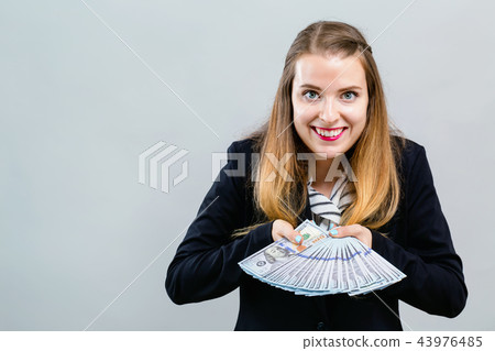 Young woman with a stack of cash USD Young woman with a stack of cash USD 43976485