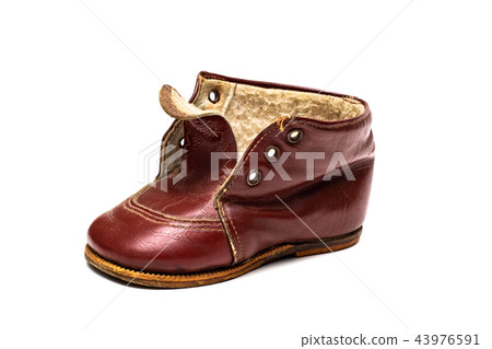 One Old red baby shoe on a white background 43976591