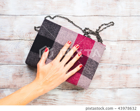 Woman's winter clutch on wooden table Woman's winter clutch on wooden table 43978632